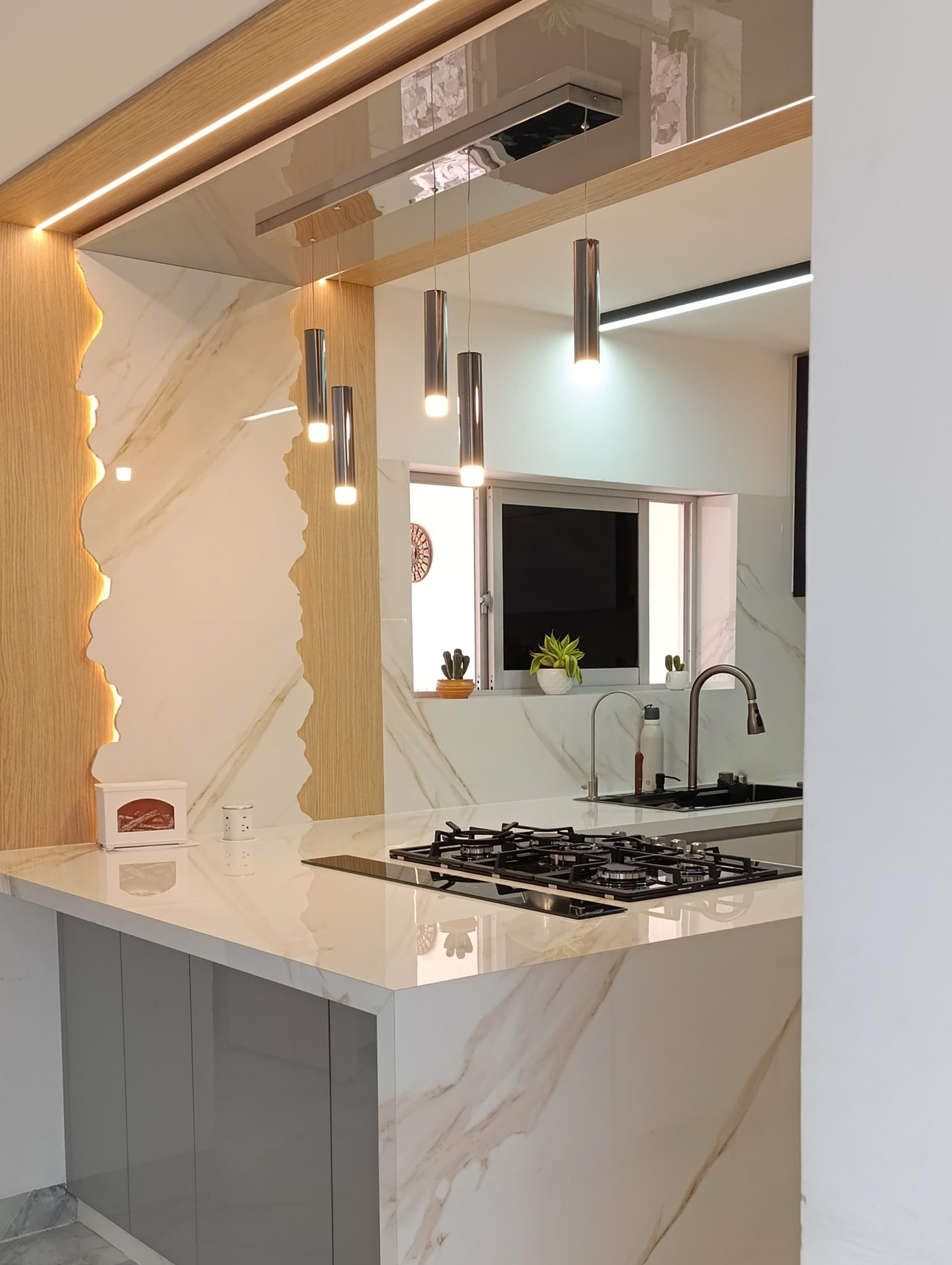 Cocina moderna Altaviza con isla en mármol y luces colgantes