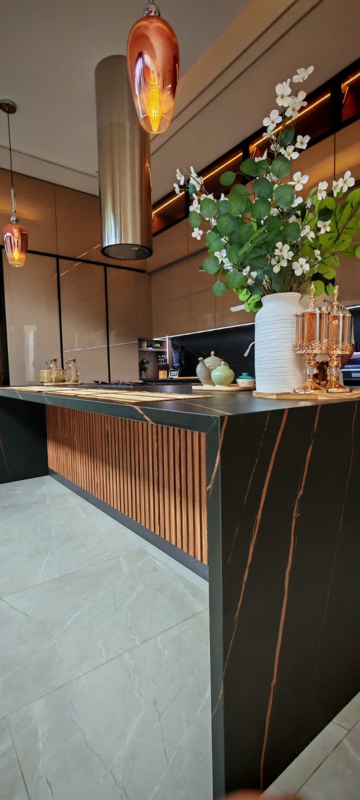 Isla de cocina en piedra oscura con paneles de madera